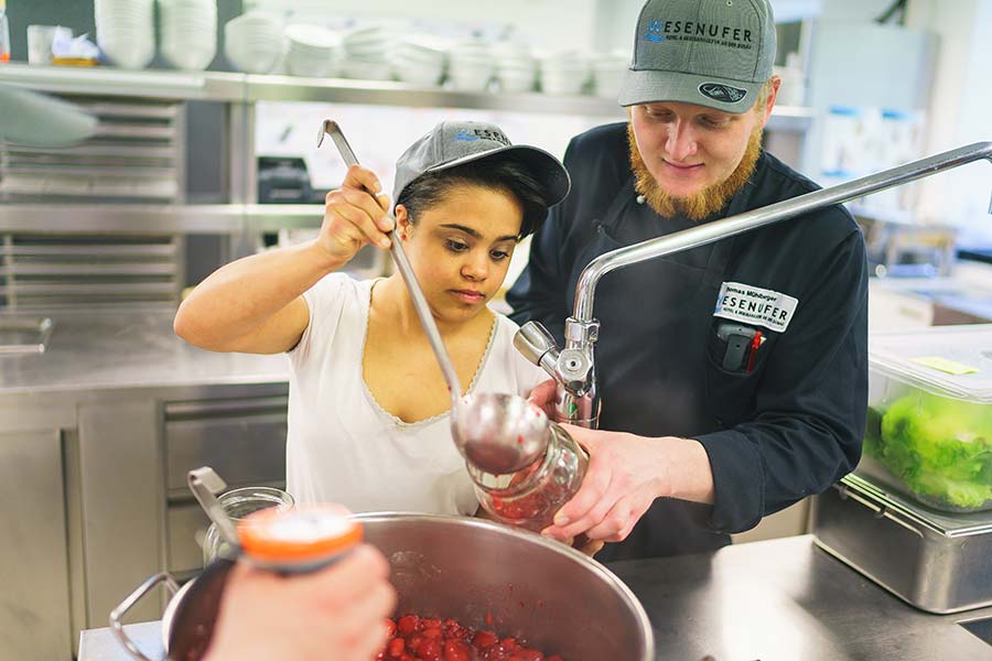 Lehrling mit Küchenchef beim abfüllen